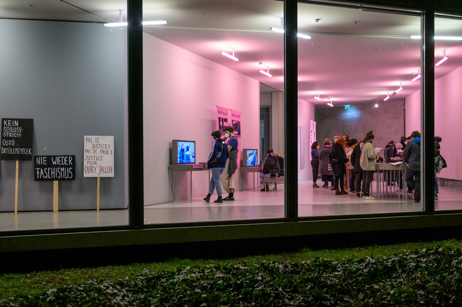 Außenansicht in den GfZK Neubau, Menschen schauen sich Werke der Ausstellung an.